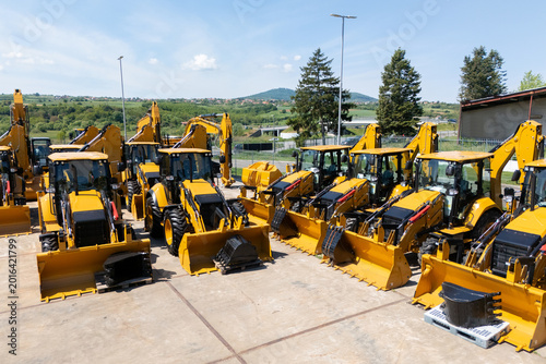 New hydraulic excavators and tractors parked at a construction machinery dealership