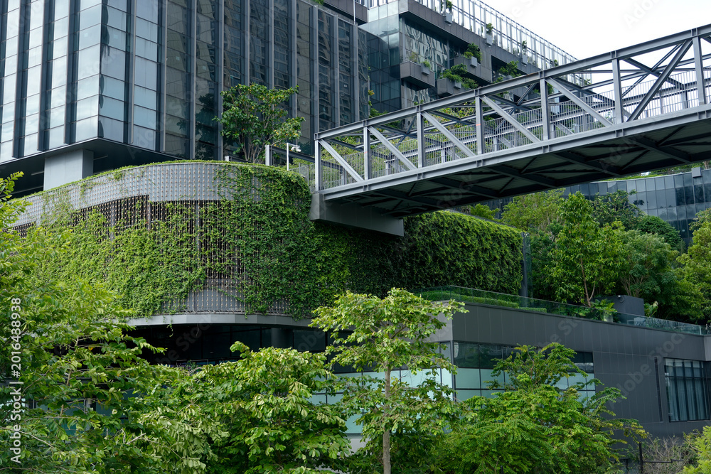 Fototapeta premium A stunning building covered in greenery stands out against the city skyline, showcasing an innovative design that celebrates urban nature and sustainability.