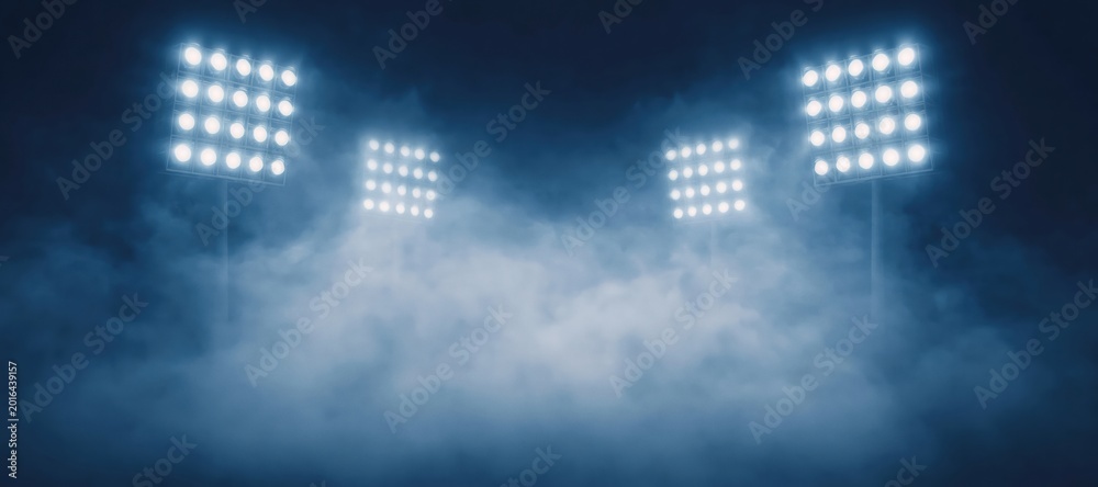 Naklejka premium Stadium floodlights shining through thick smoke or fog, creating a dramatic atmosphere for sports, concerts, or events