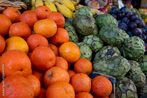 fresh citrus fruits and cherimoyas displayed at a vibrant local farmer's market