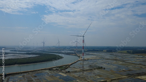 Slika na platnu Aerial view of wind turbines with red and white stripes rising from the Salty fi