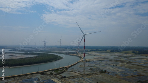 Картината върху платно Aerial view of wind turbines with red and white stripes rising from the Salty fi