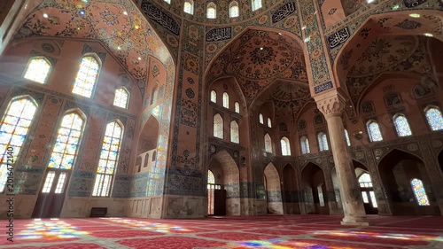 Vibrant Light in Nasir al-Mulk Mosque Prayer Hall - The intricately decorated prayer hall of the Nasir al-Mulk (Pink) Mosque in Shiraz, Iran, showcases stunning architectural details.