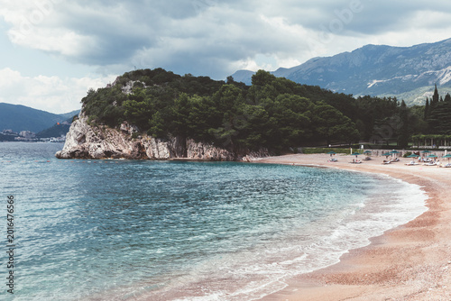 Bild auf Leinwand Wide view of a pebbly beach and clear turquoise water near Sveti Stefan, Budva M