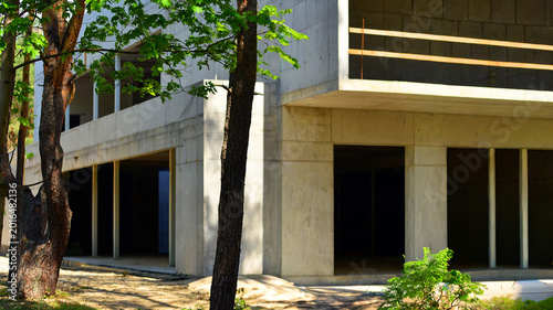 Bild auf Leinwand An abandoned concrete building under construction surrounded by a forest