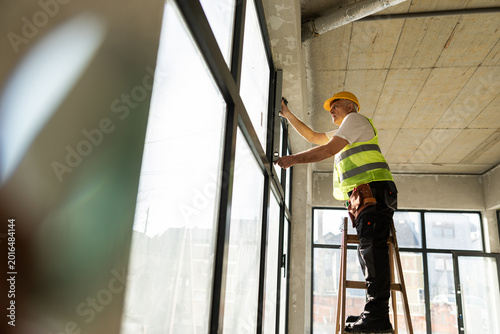 Worker Installs Window Frames in a Construction Site During Morning Hours on a Weekday