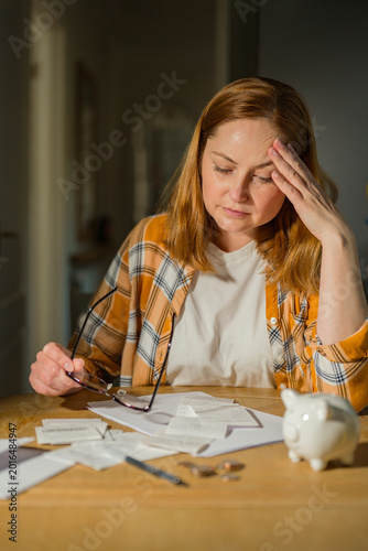 Cost of living crisis concept with worried woman counting coins at home