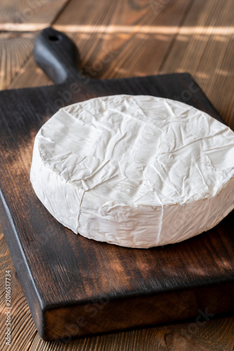 Whole Camembert Cheese Wheel Resting On Dark Rustic Wooden Serving Board Elegantly