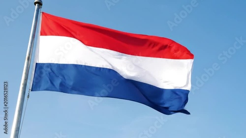 Dutch flag waving against a clear blue sky