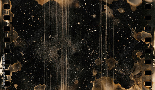 Heavily damaged vintage 35mm Kodak safety film strip with brown stains scratches dust and sprocket holes