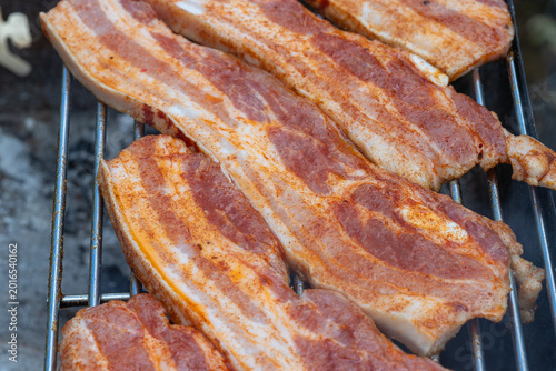Pork belly slices cooking on barbecue grill