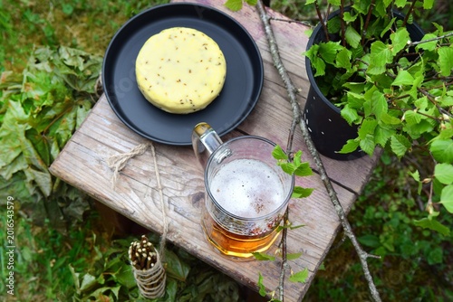 Foto Traditional Latvian caraway cheese and beer on a wooden stool with fresh birch b