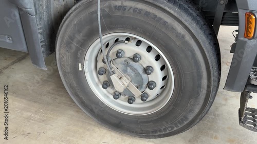 Truck wheel with visible tire pressure monitoring system sensor, showcasing gradual changes in tire condition and maintenance checks