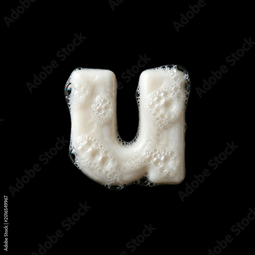 Solid soap with bubbles and foam letter U - Small creative font isolated on black background. Perfect alphabet for creative illustrations related to beauty, hygiene, purity...