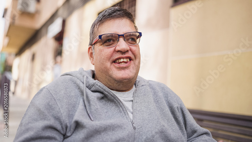 Cuadro en lienzo Happy man with glasses and disability smiling outdoors, representing inclusion,