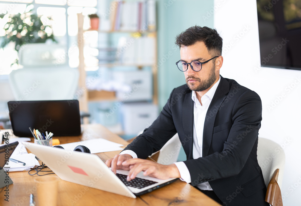 Fototapeta premium Man working in office, manager using laptop in work. Regional representative office company, carsharing, hiring staff.