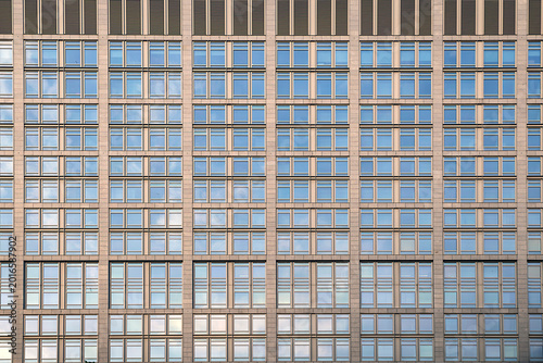 Berlin, Germany, architectural close up of a modern office building glass facade reflecting the sky.