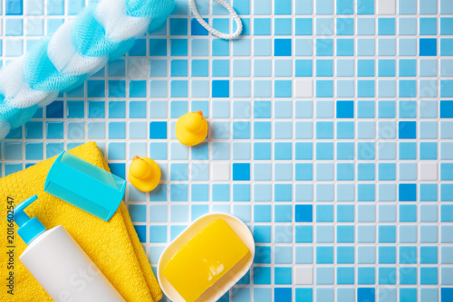 Billede på lærred Grooming and playtime mix: yellow ducks, blue comb, baby shampoo, and towel on mosaic tiles