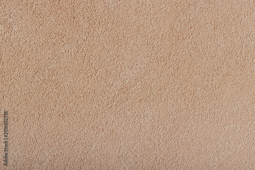 A beautiful textured background made of uneven granules of a creamy chocolate color.
