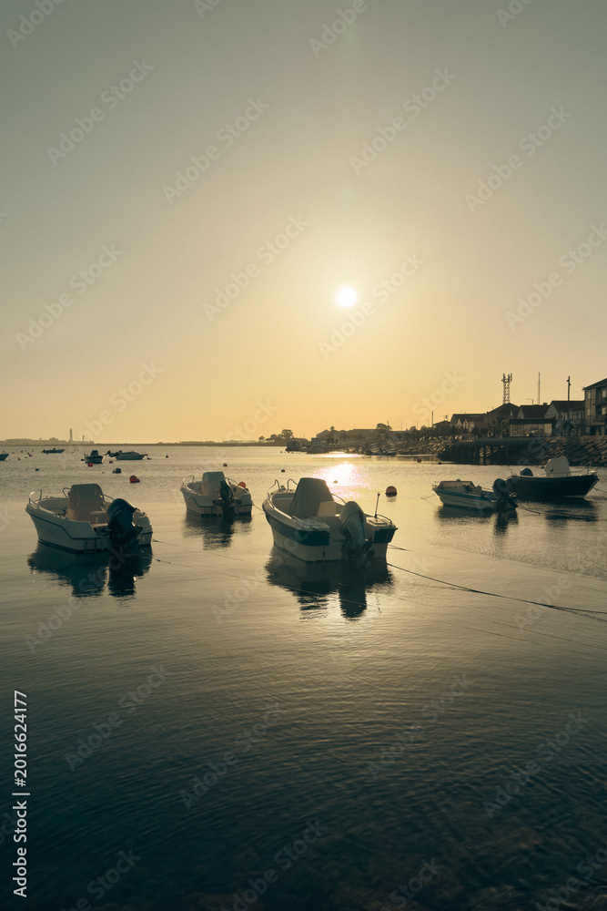 Fototapeta premium Boats Anchored at Cais de Sao Jacinto Pier in Aveiro Portugal at Sunset