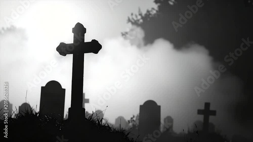 A hazy graveyard scene features silhouetted crosses and tombstones against an ethereal sky