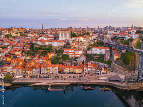Drone view of Ribeira in Porto, Portugal, with Douro River, Dom Luis I Bridge and rabelo boats along the Douro waterfront
