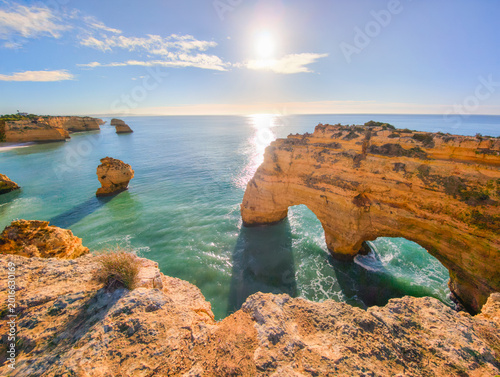 View of Praia da Marinha beach in Algarve, Portugal, with ocean cliffs, sea stacks and weathered cliff textures.