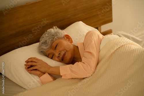 ベッドで眠るシニア女性　ライフスタイルイメージ