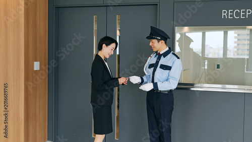 Bild auf Leinwand 女性スタッフのIDをチェックする男性警備員