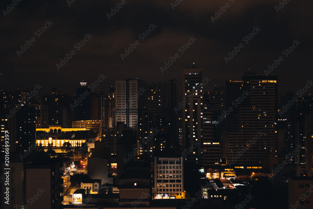 Fototapeta premium Paisagem Urbana Noturna de Curitiba com Edifício Iluminado em Destaque