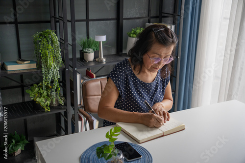 Foto Senior Asian woman Write a diary in a notebook