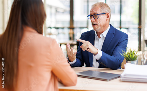 Foto Senior businessman mentoring young professional woman in office