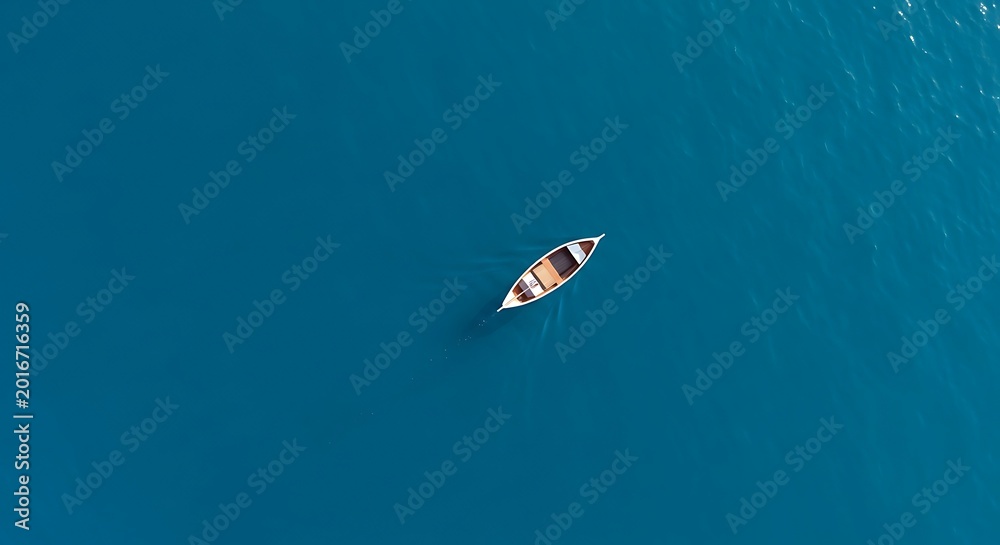 Fototapeta premium Aerial Top View of a Rowboat on Deep Blue Ocean Water