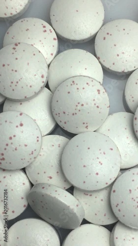 Close-up of a scattering of pills. Vertical video.