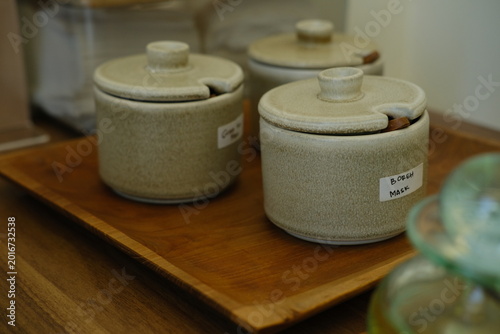 Three Ceramic Salt Jars with Wooden Spoons on Wooden Tray