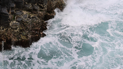 Billede på lærred High Angle View of Ocean Waves Crashing Against Dark Basalt Rocks