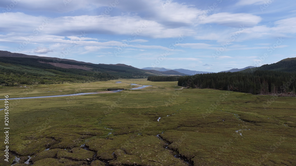 Naklejka premium Aerial View of a Winding River Through Scottish Highland Valley