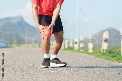 Fotografie Young adult male runner with knee pain from ACL injury or patellofemoral syndrome