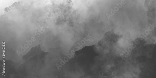 Фотография Atmospheric thick smoke and heavy fog over dark rocks, dramatic gray mist backgr