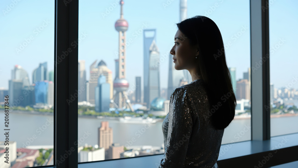 Fototapeta premium Cityscape contemplation: A graceful silhouette gazes out from a modern window at a cityscape of skyscrapers and iconic towers, invoking a sense of aspiration and introspection.