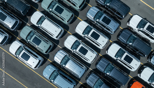Aerial drone view of thousands of new cars parked at port for global export.
