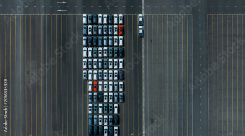 Aerial drone view of thousands of new cars parked at port for global export.