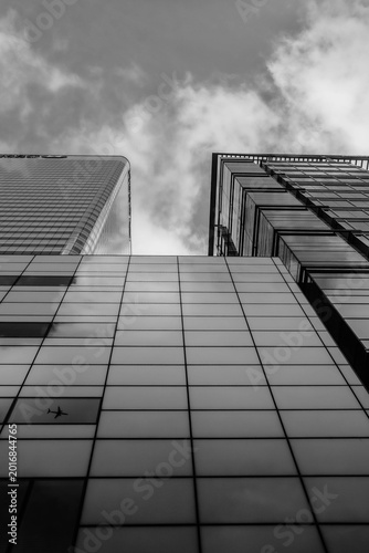 Modern Glass Skyscrapers Reaching Into a Cloudy Sky With Reflected Urban Geometry , skyscraper in the sky