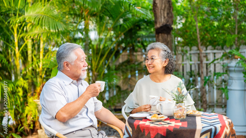 Принти на полотні Happy Asian family senior couple enjoy afternoon tea together in the garden, eld