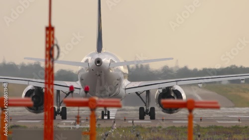 Jet airplane accelerating for takeoff, rear runway view. Concept of travel and aviation.