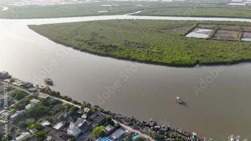 A breathtaking aerial landscape showcasing a coastal fishing harbor beside vast mangrove wetlands and waterways.