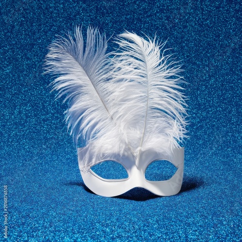 White Mask With Feather on Blue Background for Carnival or Costume Party Deco...