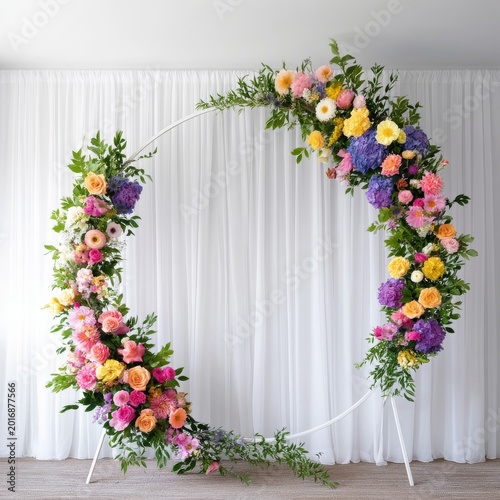 Flower Arrangement in a Circular Frame Placed in Front of White Curtains Indoors
