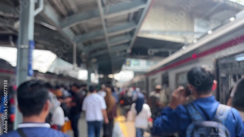 Morning scene at a train station in Jakarta, during rush hour, people are rushing to and from work. The video is blurry.