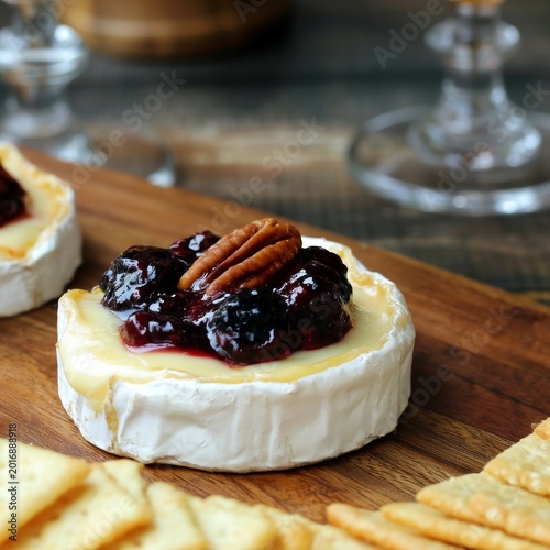 Cheese and Crackers With Jam and Nuts on a Wooden Board During a Snack Time G...